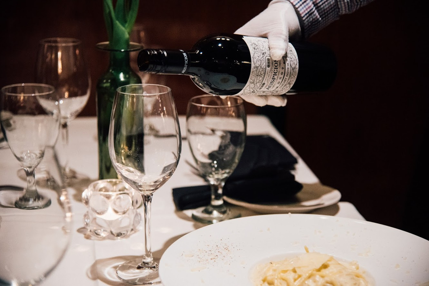 Employee pouring red wine for the guests